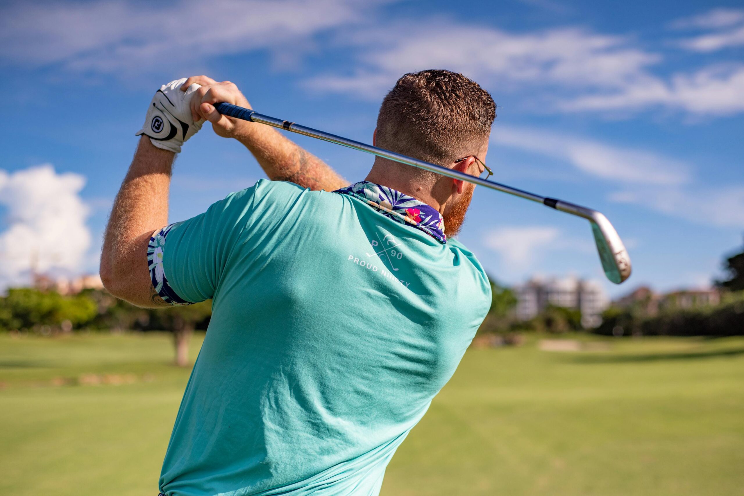 Male golfer taking a swing on a sunny golf course in Boca Raton, Florida.