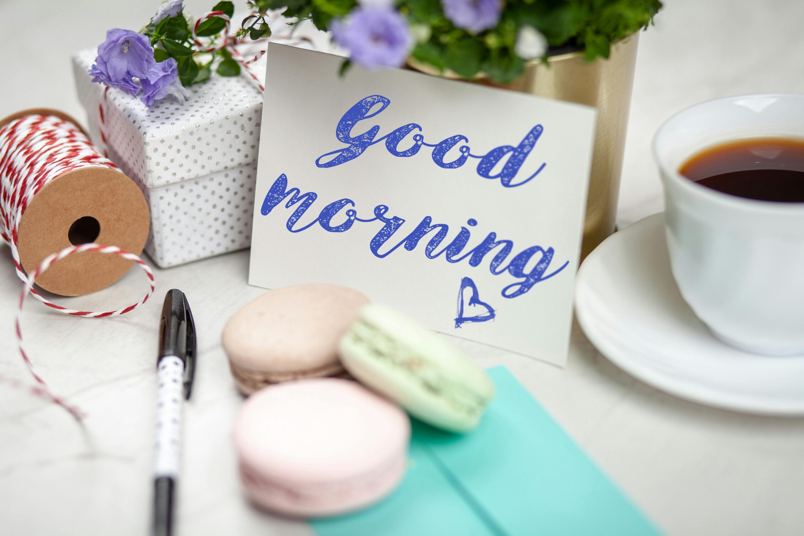 Good morning card with coffee, macarons, and gifts creating a cozy scene.