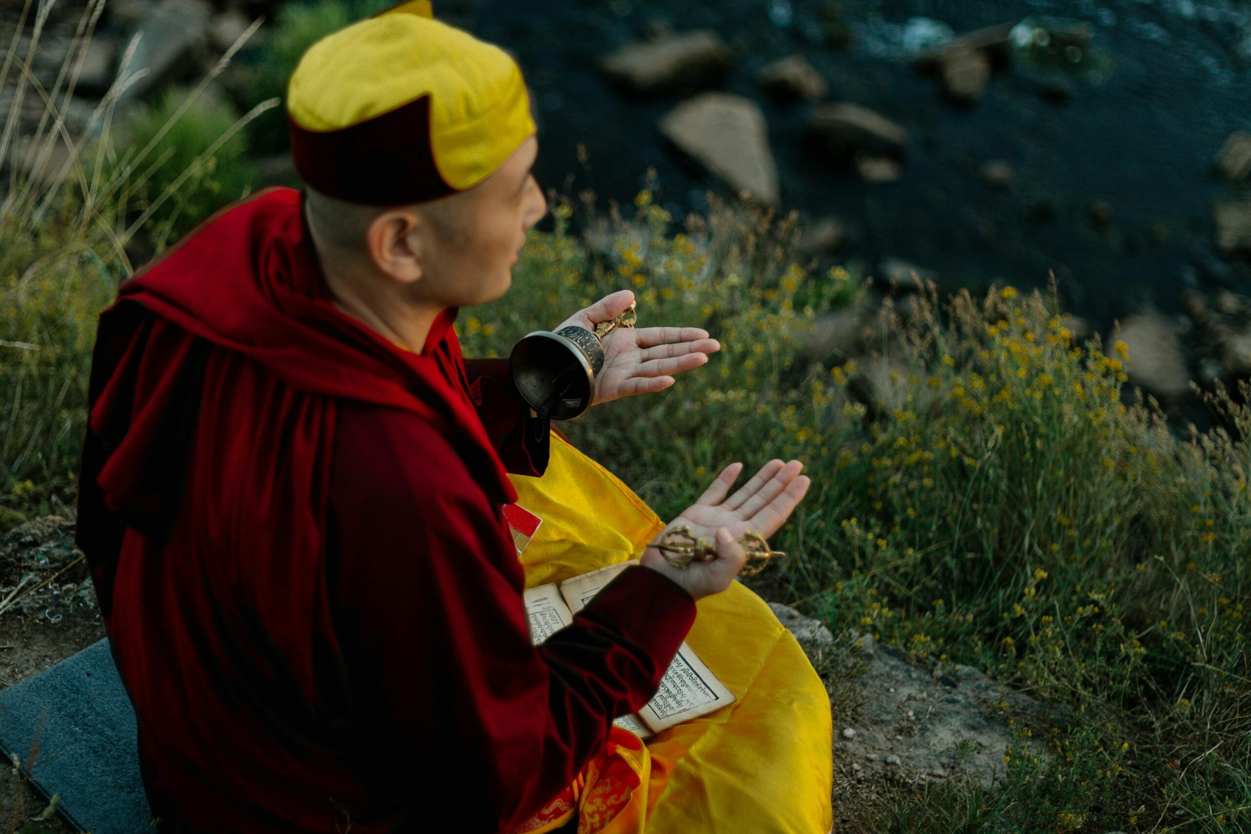 A monk meditating on a riverbank, capturing spiritual tranquility and nature's beauty.