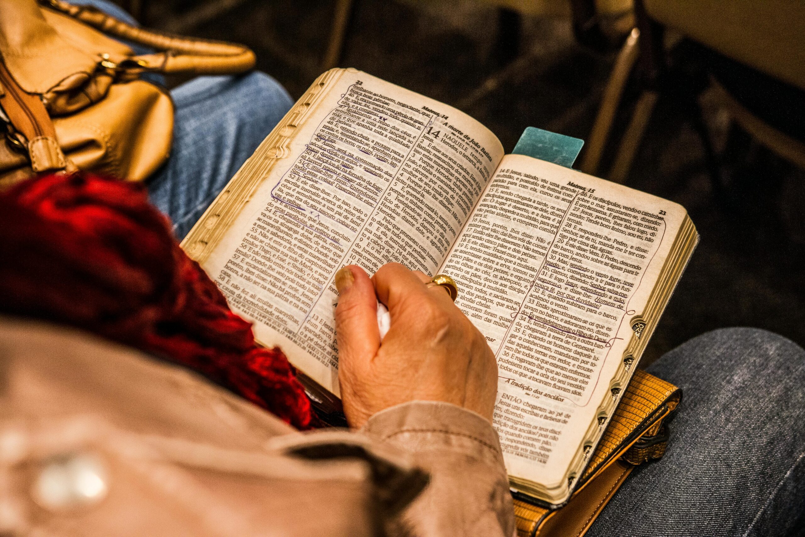 A person reading a Bible indoors, symbolizing spirituality and devotion.