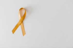 Golden ribbon symbolizing awareness on a white background, perfect for campaigns.