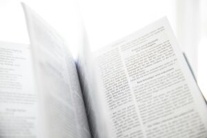 Close-up of an open book with visible text and turning pages in natural light.