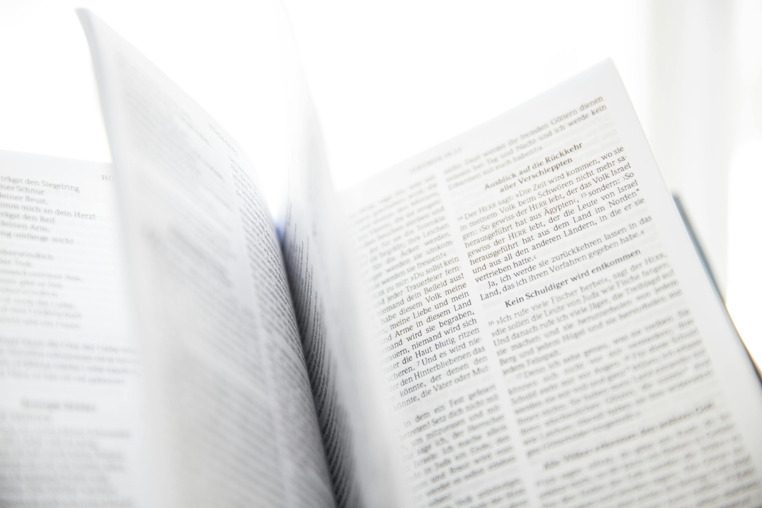 Close-up of an open book with visible text and turning pages in natural light.